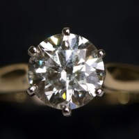 A very large diamond ring on a black background.